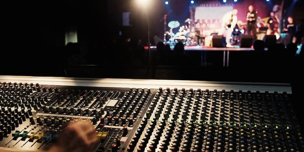 A mixing desk overlooking a live stage performance